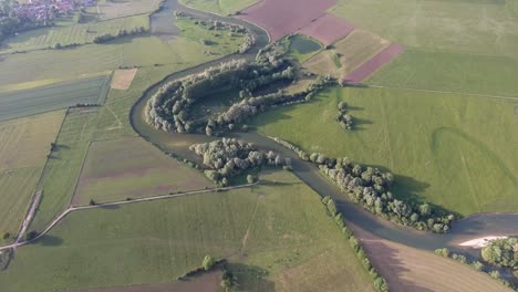 Ländliche-Landschaft-In-Frankreich.-Fluss-Mit-Feldern-Drumherum,-Drohnenansicht